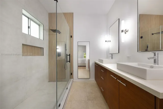 a large bathroom with a double vanity sink a mirror and a shower
