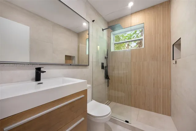 a bathroom with a sink a toilet and shower