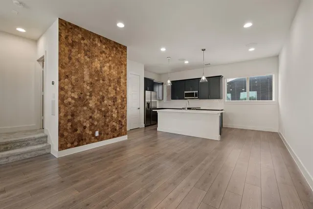 a view of a kitchen with wooden floor and electronic appliances