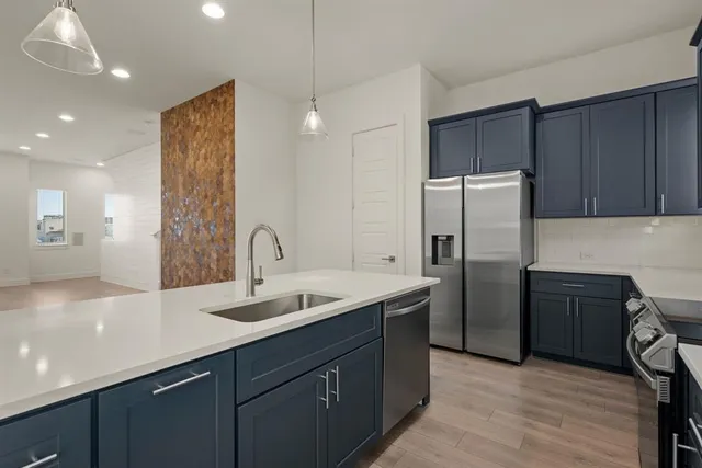 a kitchen with refrigerator sink and cabinets