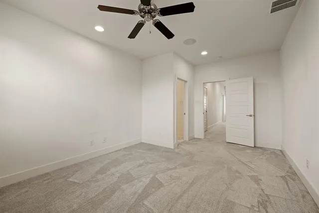 a view of an empty room and chandelier fan