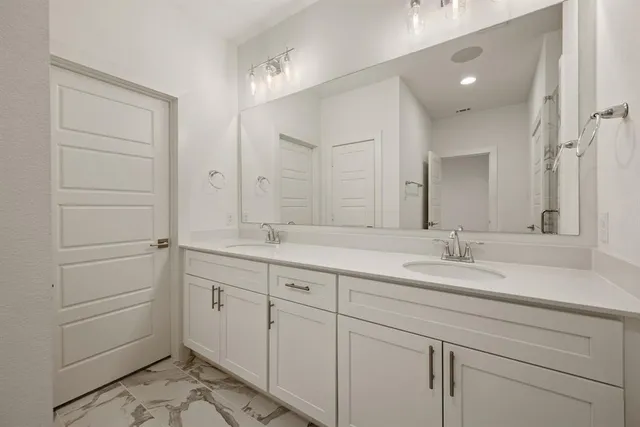 a bathroom with a double vanity sink and mirror