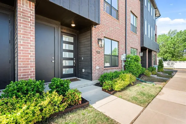 front view of a brick house with potted plants