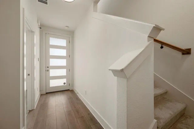 a view of hallway with stairs and wooden floor