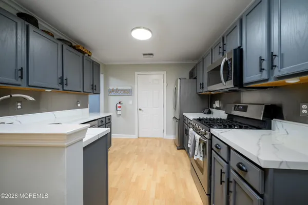 a kitchen with stainless steel appliances granite countertop a sink a stove and a refrigerator