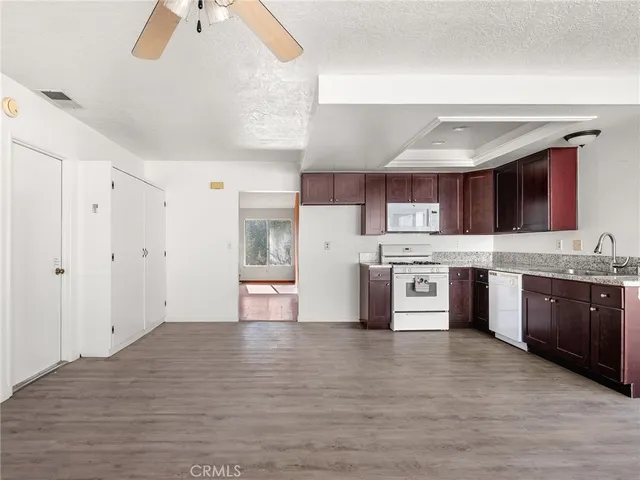 a large kitchen with stainless steel appliances granite countertop a stove a sink dishwasher and a refrigerator