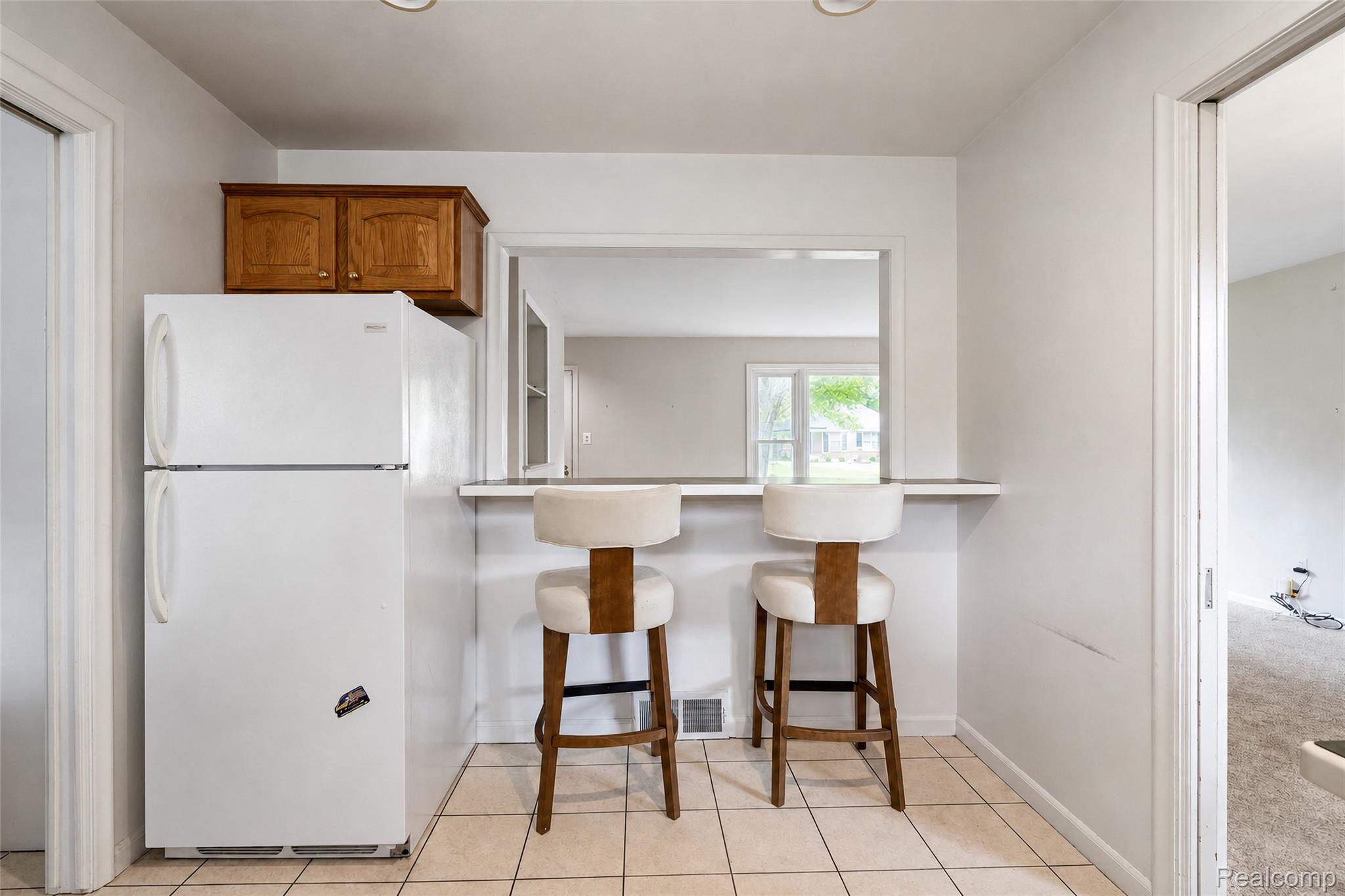 1846 Pembroke Road Birmingham, MI 48009 - Photo 26 of 37 Kitchen area featuring overhead cabinetry, tile flooring, and a pass-through opening