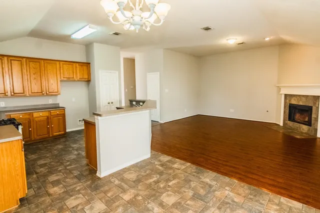a view of a kitchen with a sink hardwood floor and a fireplace