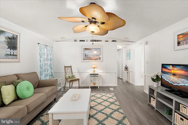 a living room with furniture a chandelier and a flat screen tv