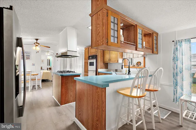 a kitchen with stainless steel appliances a sink a stove a refrigerator and cabinets