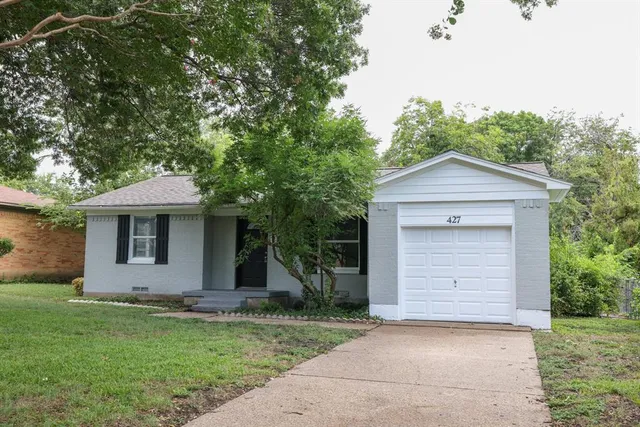 a front view of a house with a garden and yard