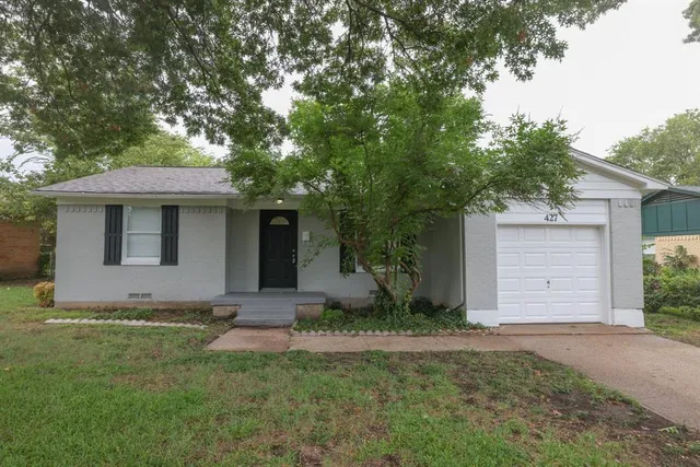 a front view of a house with a garden and yard