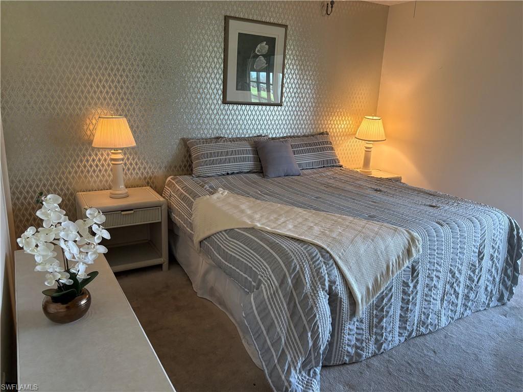 315 St Andrews Boulevard, Unit A2 Naples, FL 34113 - Photo 8 of 17 Carpeted bedroom with wallpapered walls