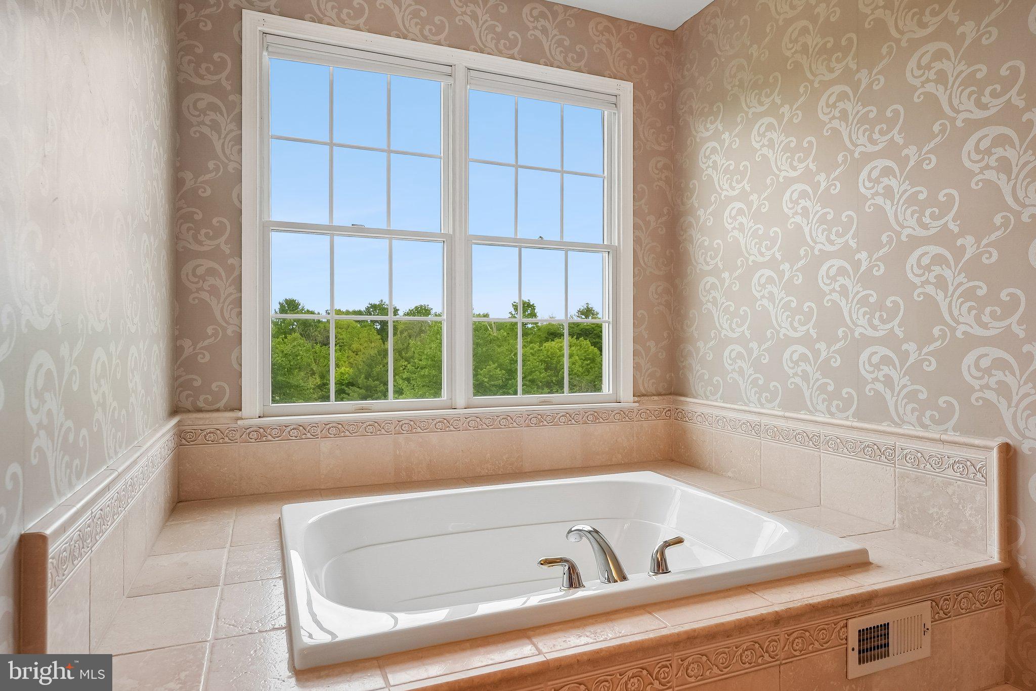 1 Baker Way Pennington, NJ 08534 - Photo 37 of 77 a white bath tub sitting in a bathroom next to a window