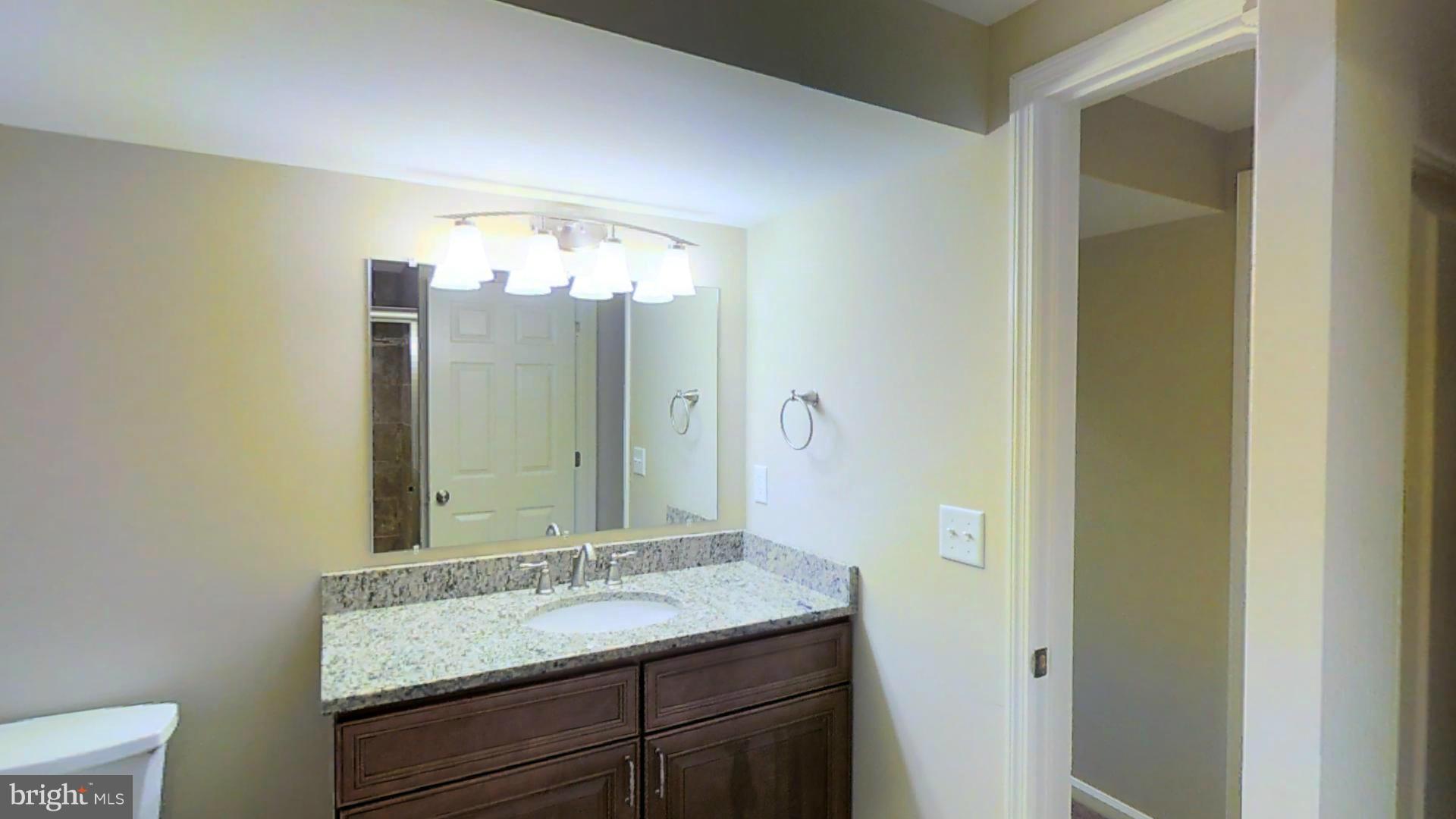 4527 Mountville Road Frederick, MD 21703 - Photo 14 of 26 a bathroom with a granite countertop sink a large mirror and a shower