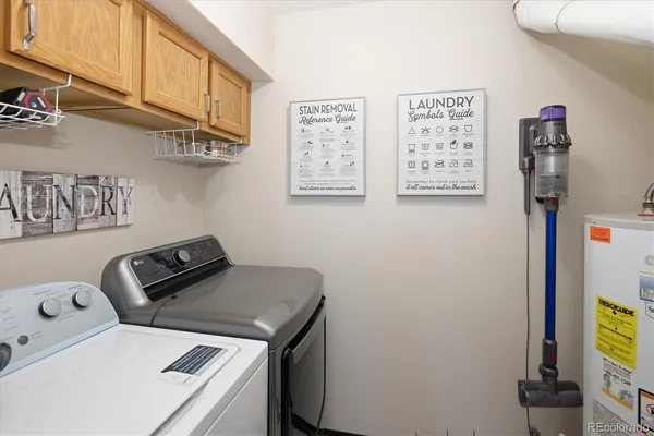 a utility room with fridge and wall