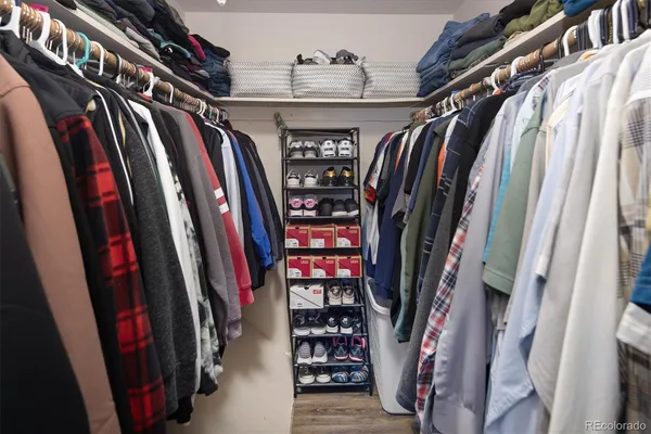 a view of walk in closet with clothes and shoes