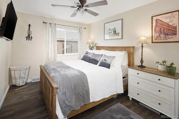 a bedroom with a large bed and a flat tv screen on dresser