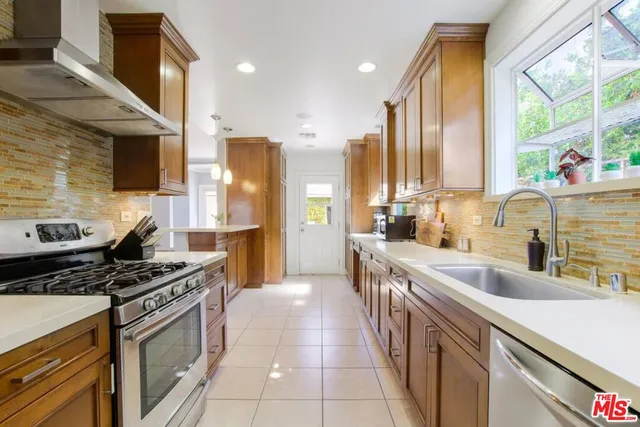 a kitchen with stainless steel appliances a sink stove and cabinets