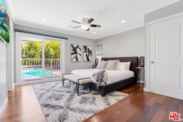 a bedroom with a bed a table and wooden floor