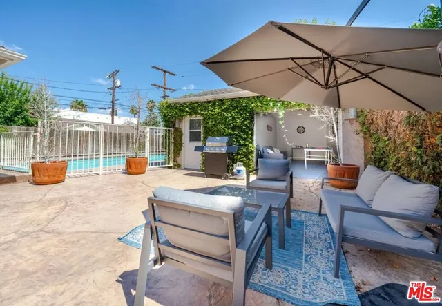 a view of a patio with a table chairs and a potted plant