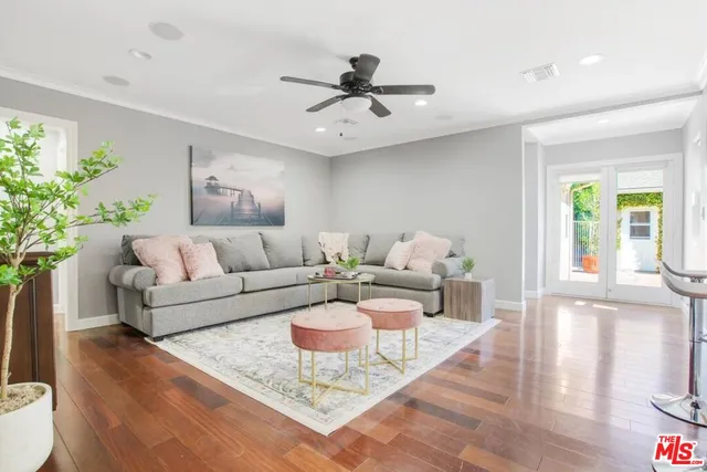 a view of a patio with couches table and chairs under an umbrella