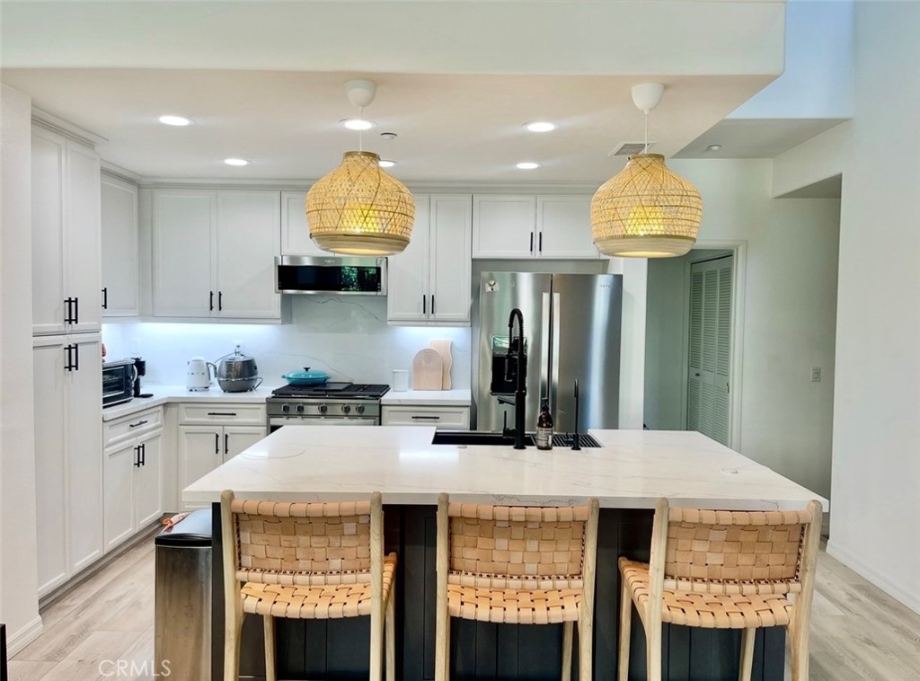 a kitchen with a sink a stove a dining table and chandelier