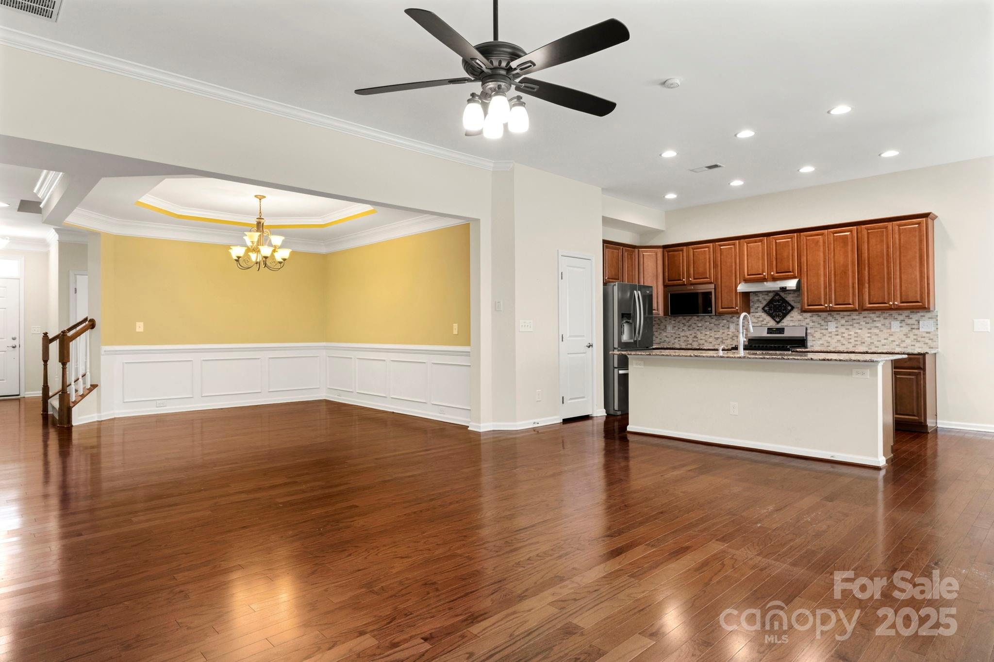 15709 Kiser Corner Lane Davidson, NC 28036 - Photo 6 of 42 a view of a kitchen with a stove wooden floor and a ceiling fan
