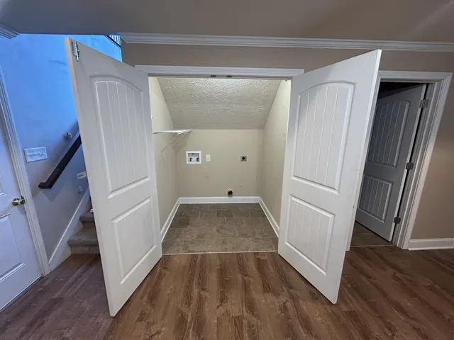 a view of a room with wooden floor and staircase