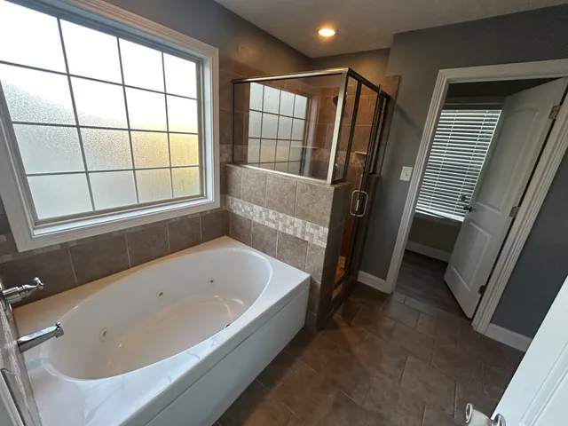 a bathroom with a bathtub and a window