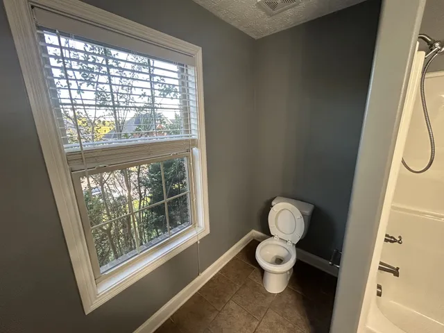a bathroom with a toilet sink and a window