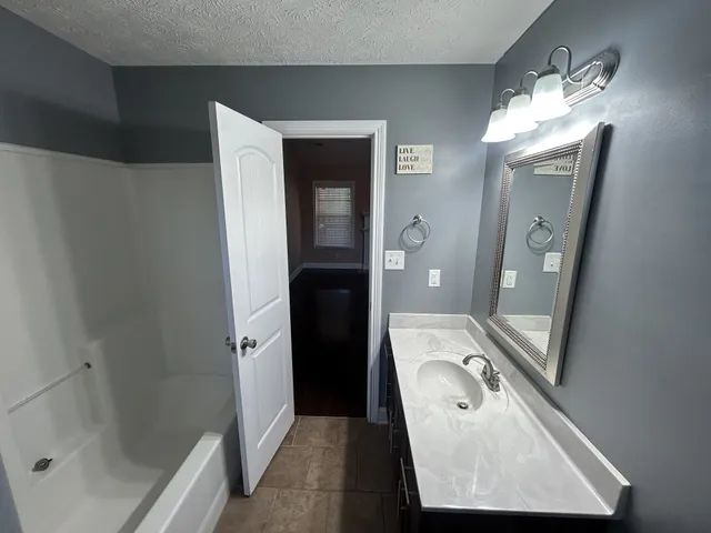 a bathroom with a sink a mirror and a shower