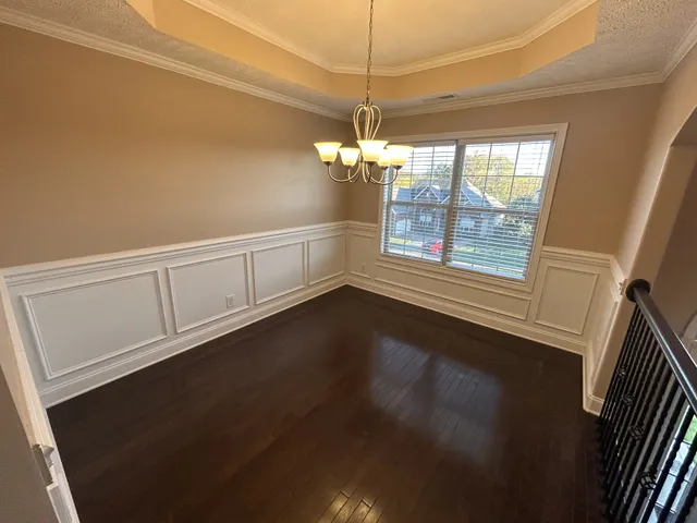 a view of a livingroom with a window and wooden floor