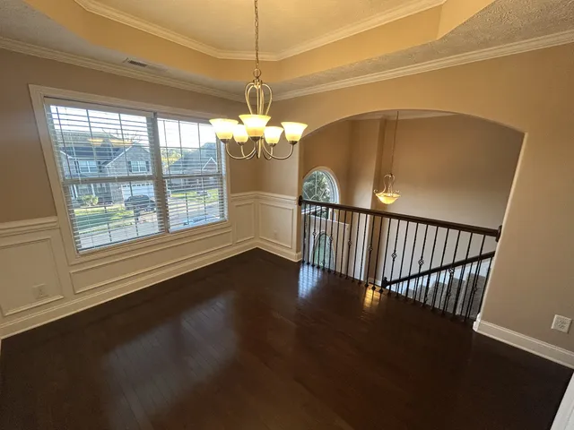 a view of a livingroom with wooden floor a ceiling fan and a window