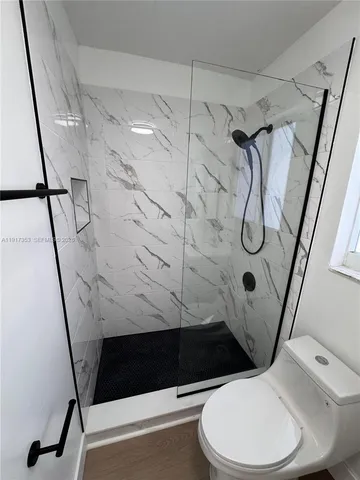 a bathroom with a toilet and a shower