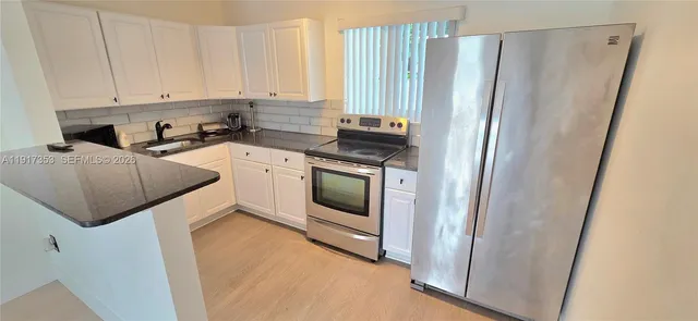 a kitchen with a refrigerator sink and cabinets