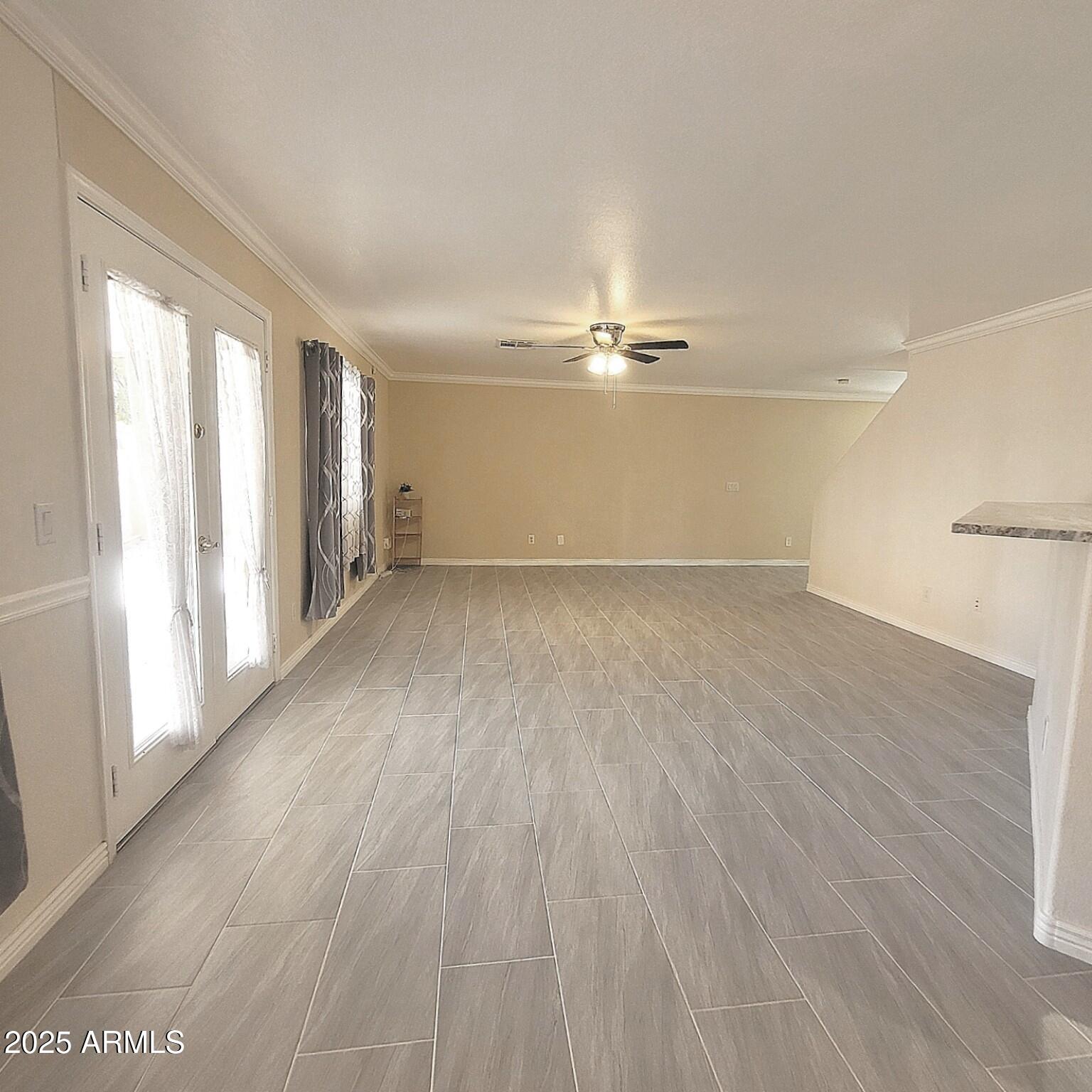 2210 East Paraiso Drive Phoenix, AZ 85024 - Photo 8 of 30 an empty room with wooden floor chandelier fan and windows