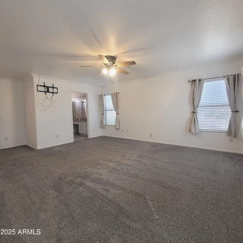 an empty room with windows and fan