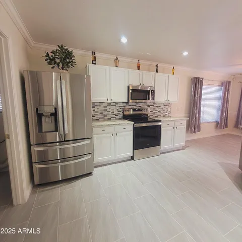 a kitchen with stainless steel appliances granite countertop a stove a sink and a refrigerator