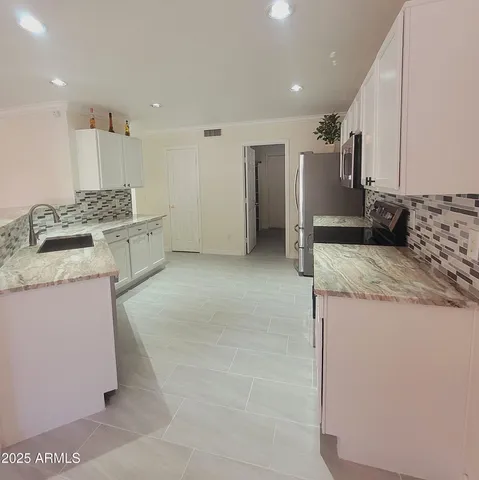 a kitchen with stainless steel appliances a refrigerator sink and stove