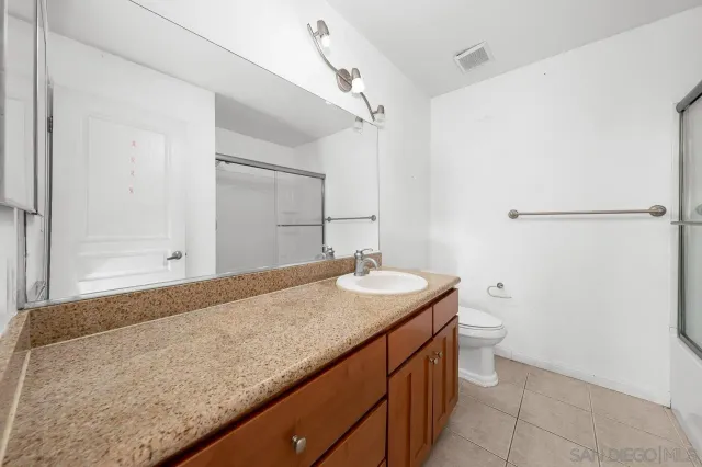 a bathroom with a granite countertop sink and toilet