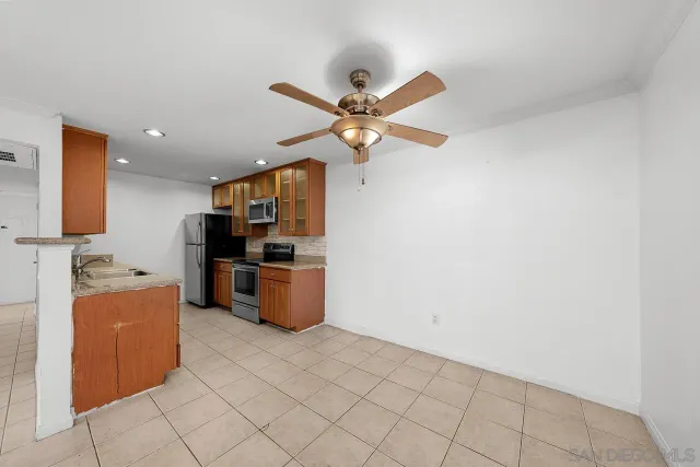 a kitchen with stainless steel appliances a stove top oven a refrigerator cabinets a sink and a stove