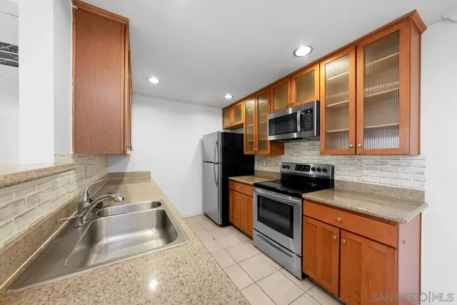 a kitchen with stainless steel appliances granite countertop a sink stove and cabinets
