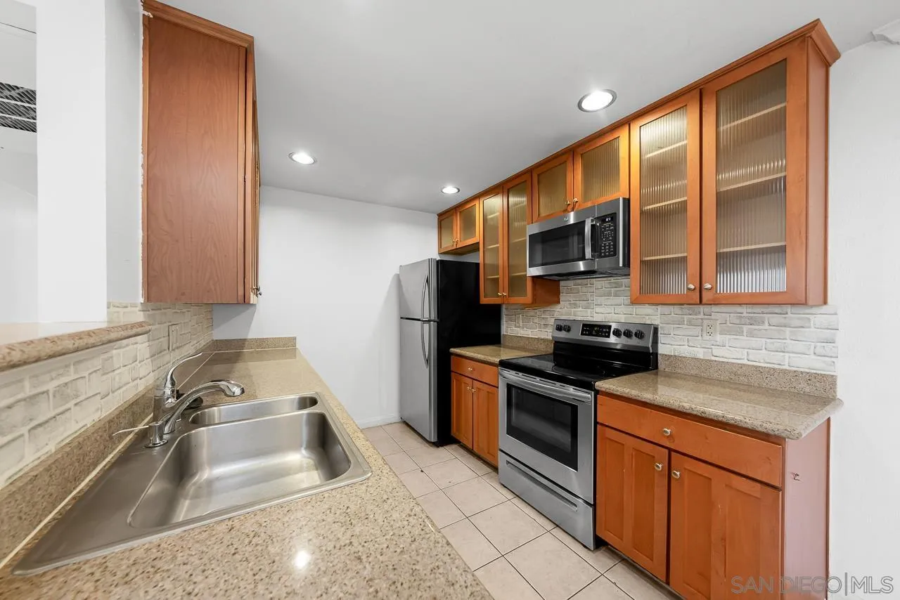 174 Chambers Street, Unit 1 El Cajon, CA 92020 - Photo 9 of 37 a kitchen with stainless steel appliances granite countertop a sink stove and cabinets