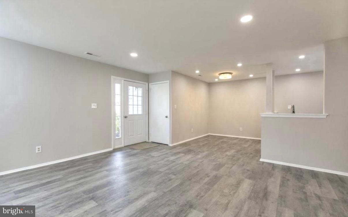 405 Quail Road Marlton, NJ 08053 - Photo 11 of 20 a view of an empty room with wooden floor and kitchen space