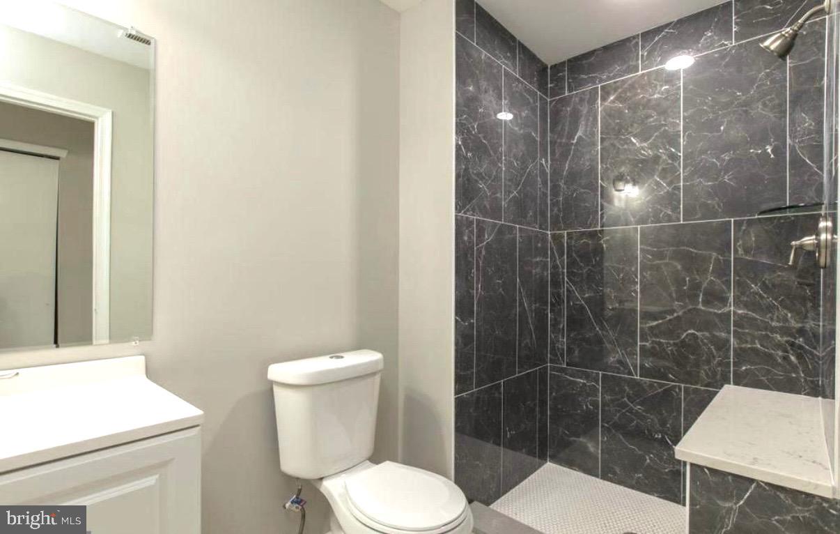 405 Quail Road Marlton, NJ 08053 - Photo 2 of 20 a white toilet sitting next to a bathroom sink and a shower