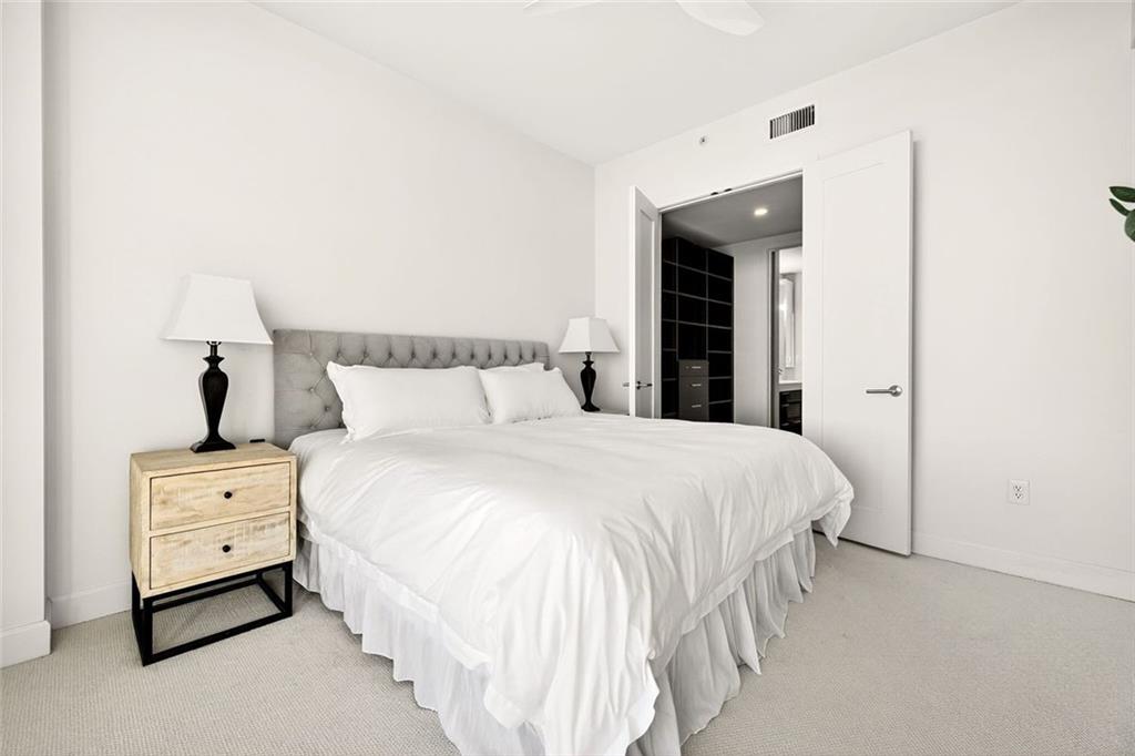 1820 Peachtree Road Northwest, Unit 905 Atlanta, GA 30309 - Photo 15 of 41 a bedroom with a bed and a night stand