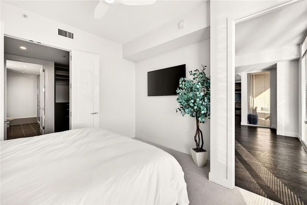 1820 Peachtree Road Northwest, Unit 905 Atlanta, GA 30309 - Photo 16 of 41 a bedroom with a bed and a potted plant