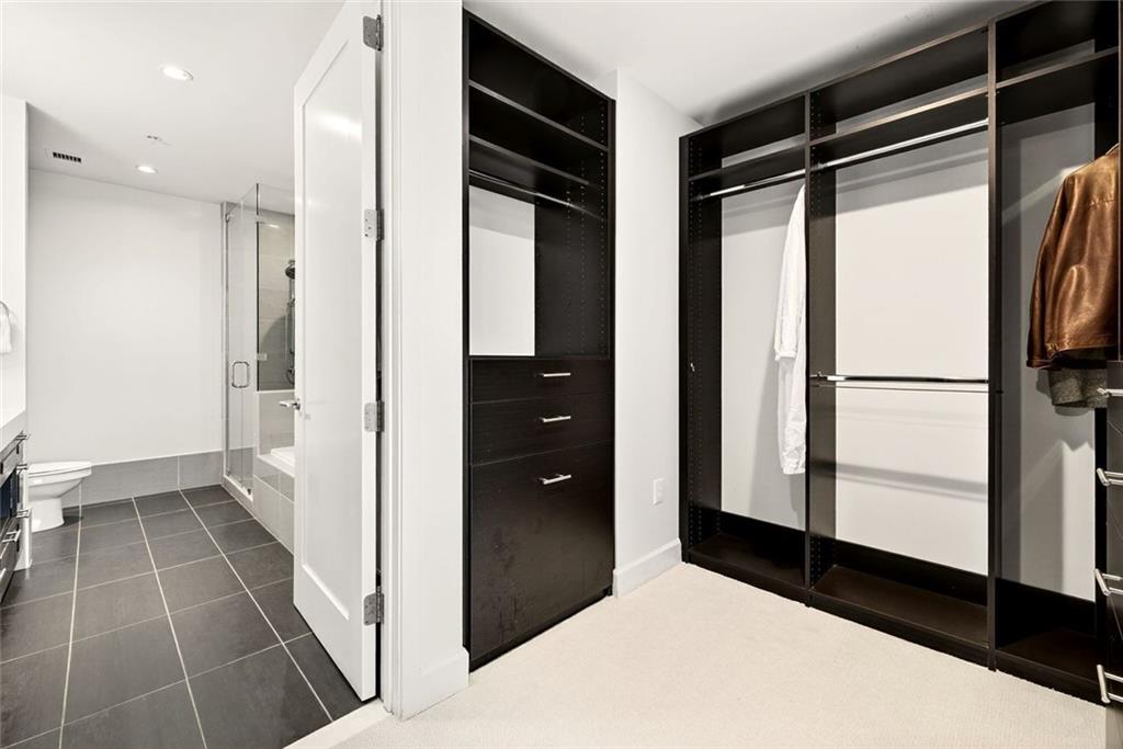 1820 Peachtree Road Northwest, Unit 905 Atlanta, GA 30309 - Photo 18 of 41 a bathroom with a glass shower door and a sink