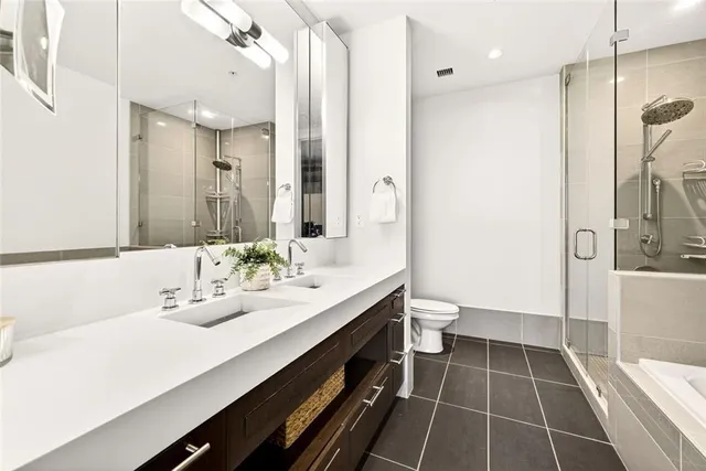 a bathroom with a double vanity sink a toilet and a shower